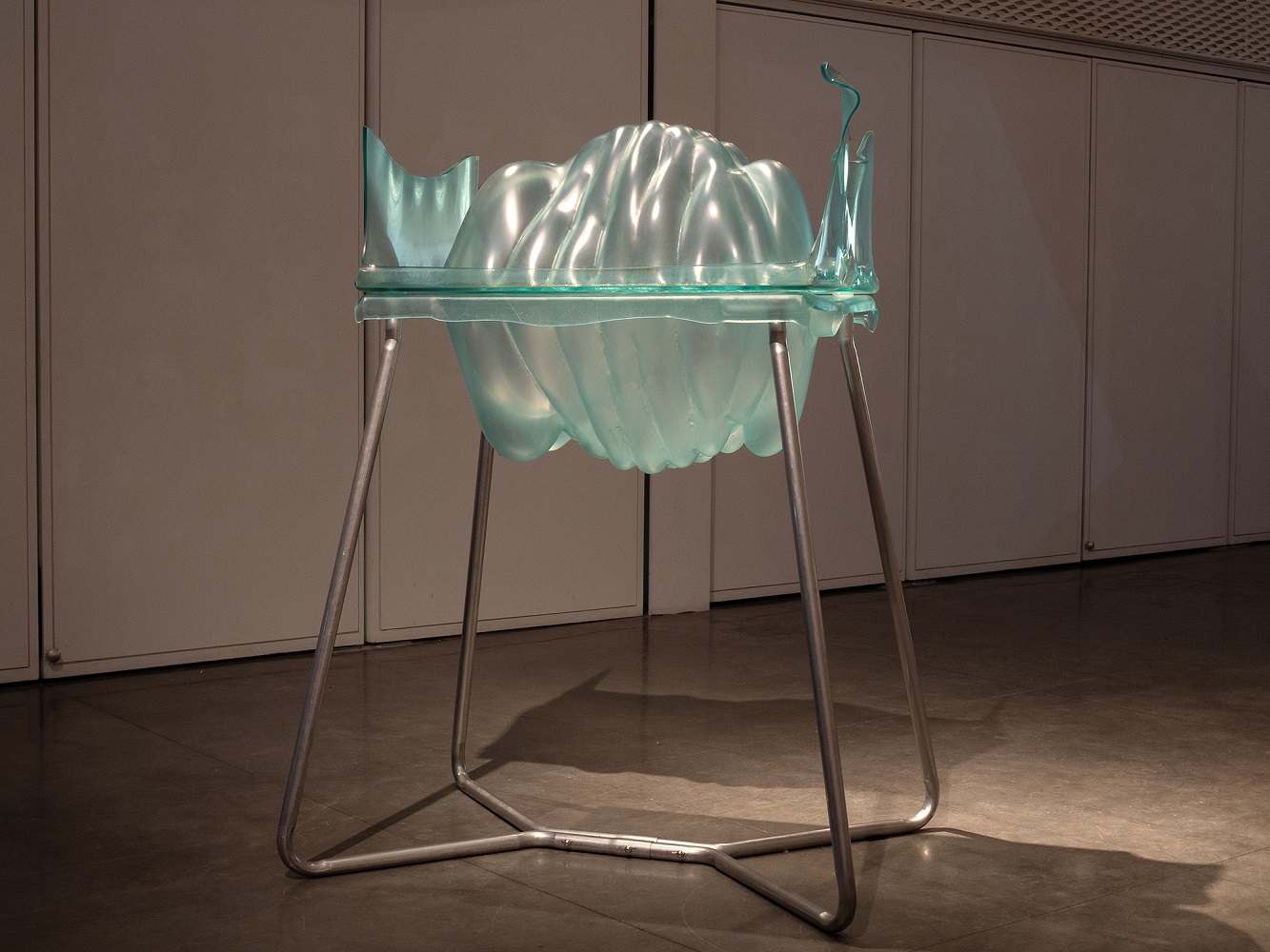 Close-up of a translucent sculpture on a metal stand with intricate details.