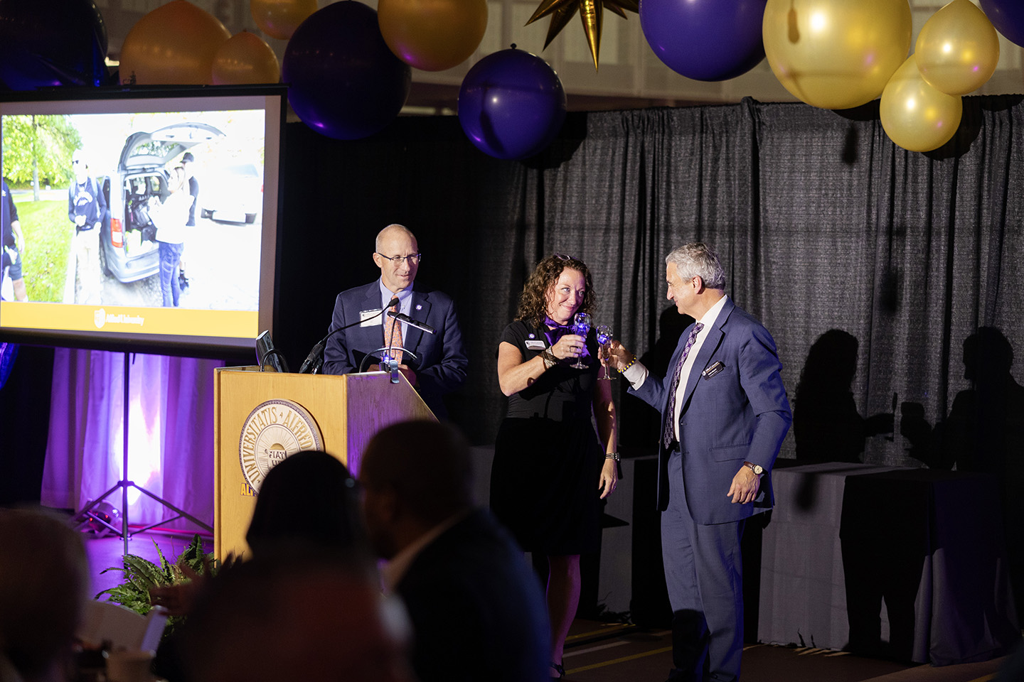 People at a podium sharing a toast