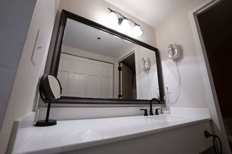 clean white countertop in white bathroom with sink and mirror