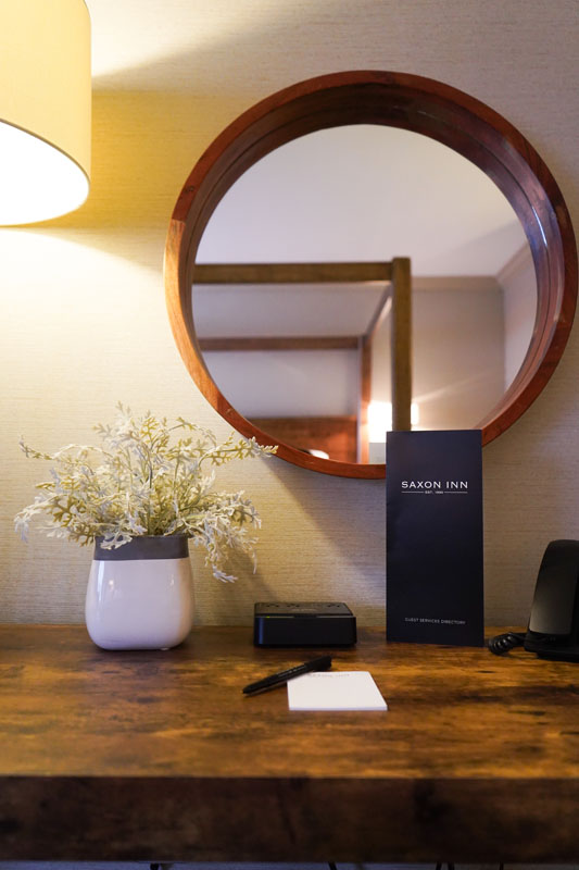 desk with notepad, flowers and a mirror
