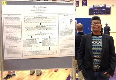 A student stands beside a research poster on race and gender during Alfred University’s Undergraduate Research Forum.