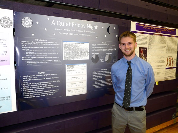 A student stands beside his research poster titled “A Quiet Friday Night” during Alfred University’s Undergraduate Research Forum.