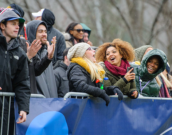 Group of students cheering on an athletic event outside
