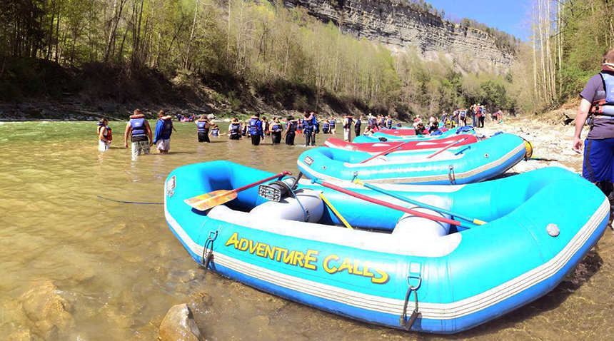 Inflatable rafts and students in a river