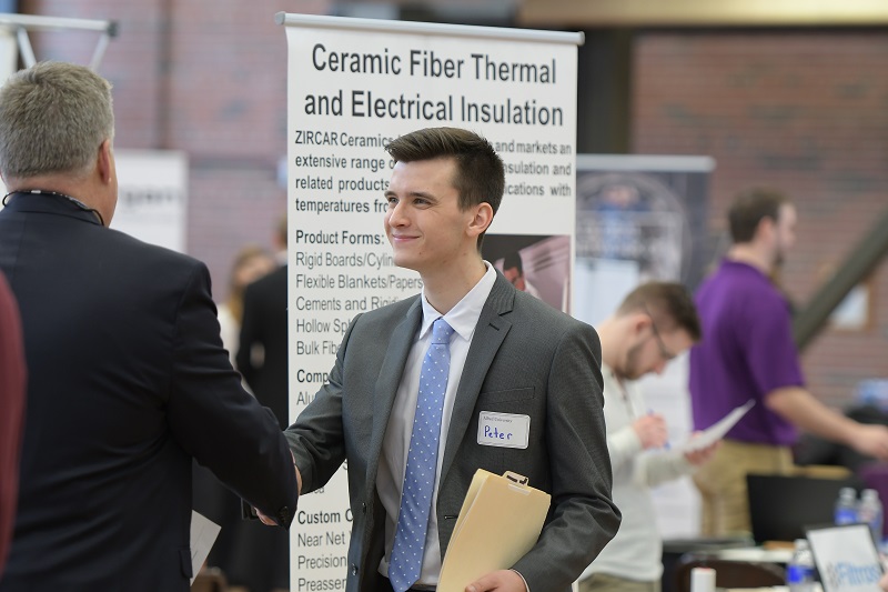 Student shaking an employer's hand at a career fair